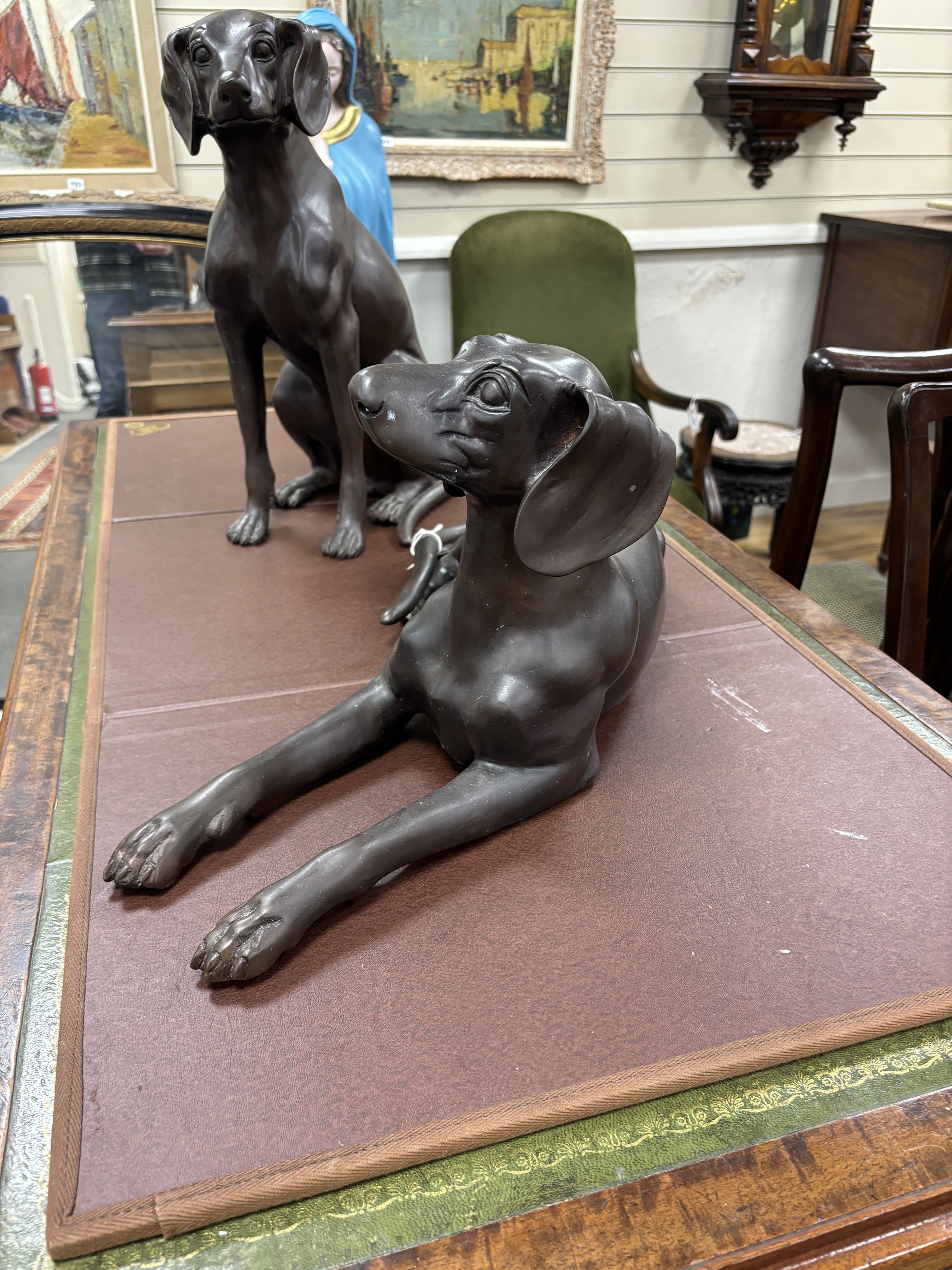 Two large bronze models of seated dogs, largest 57cm wide